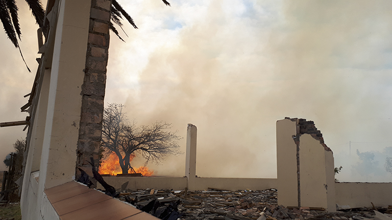 The fire tears across the old golf course – seen here through the dilapidated old clubhouse.